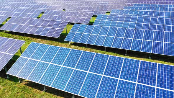 Aerial view of a huge electricity farm. Solar panels on the field in the rows at sunlight.