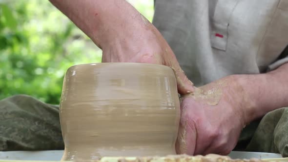 Male Potter of Caucasian Ethnicity Makes a Brown Clay Pot Moistens Clay and Draws a Mold