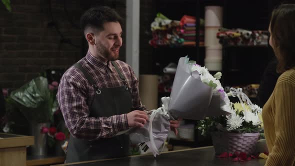Florist Gives a Bouquet of White Chrysanthemums to a Client