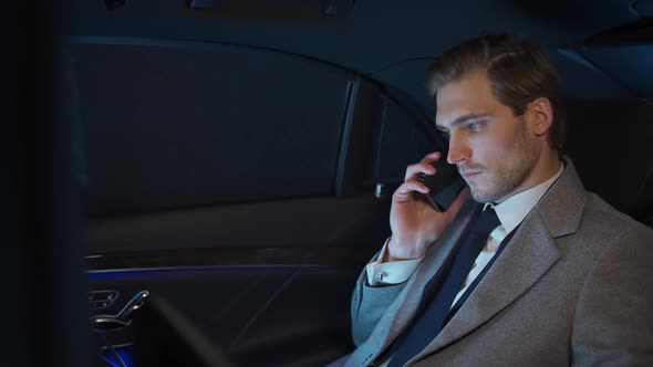 Businessman is Sitting in a Moving Car Talking on a Mobile Phone and Using Laptop Man Top Manager in