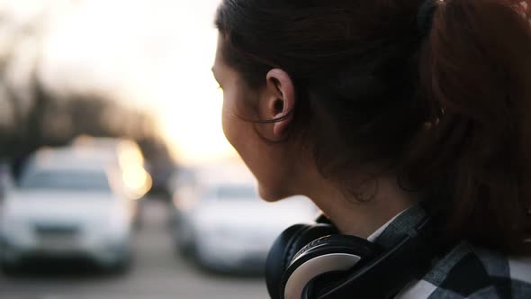 Side View of a Girl with Headphones Around Her Neck