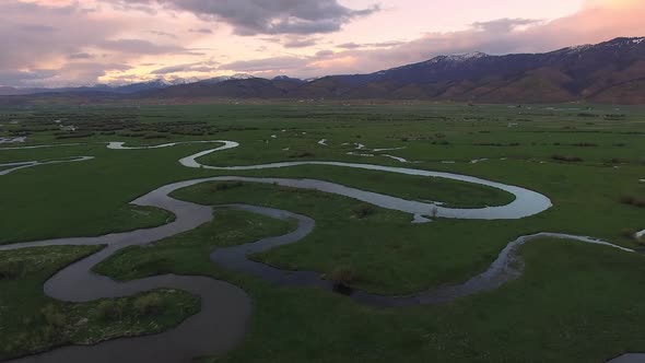 Aerial view flying over river winding through green landscape