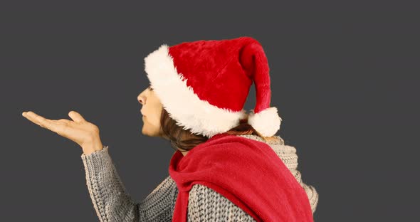 Girl in santa hat and warm clothing blowing over hands 4k