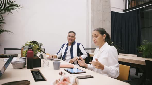 Business people at desktop with tablets and flowerpots