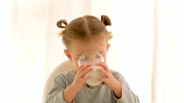 Girl Drinks Milk at Home