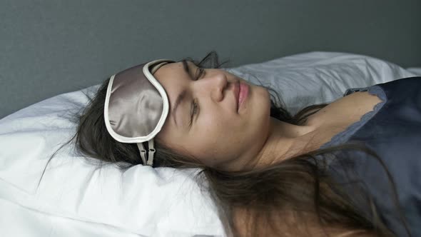 Tired Woman Falls Onto the Bed Puts on a Sleep Mask and Instantly Falls Asleep