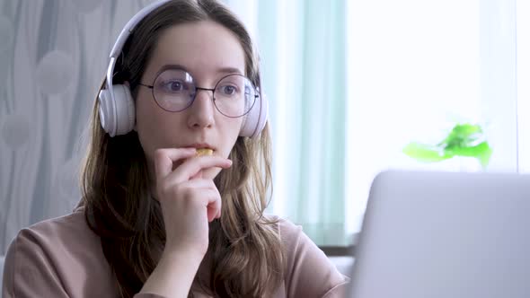 A Girl at Home Watching an Online Broadcast and Gnawing on Cookies