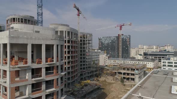 Aerial shot of construction of high-rise apartment buildings and cranes in city 08