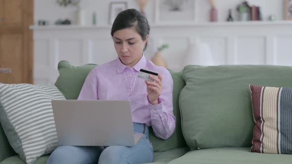 Indian Woman with Unsuccessful Online Payment on Laptop on Sofa