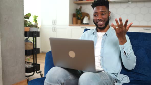 Hilarious AfricanAmerican Man Using Laptop for Video Connection Staying at Home