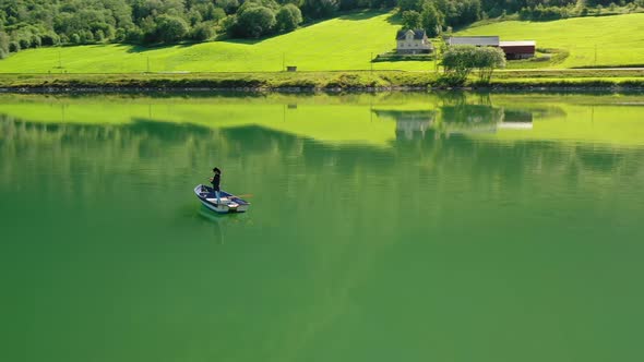 Woman on the Boat catches a Fish on Spinning in Norway