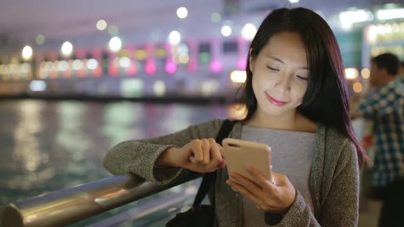 Woman use of smart phone at night in Hong Kong