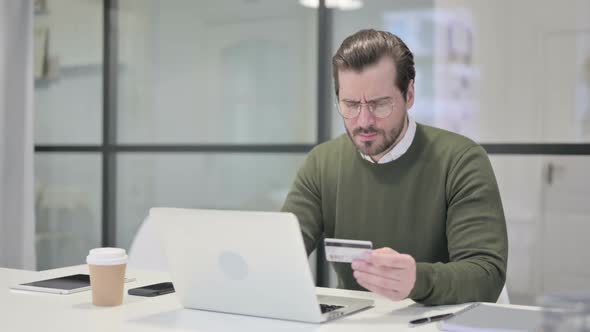 Young Businessman Making Online Payment Failure on Laptop in Office