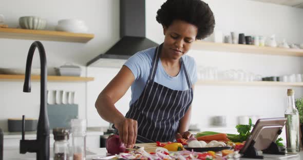 Happy african american woman preparing dinner in kitchen