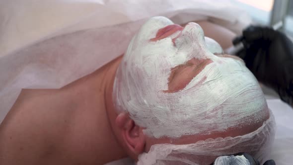 Cosmetologist Applying Mask on Client's Face in Spa Salon Top View