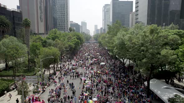 backwards drone shot of people congregated to celebrate pride parade in mexico city