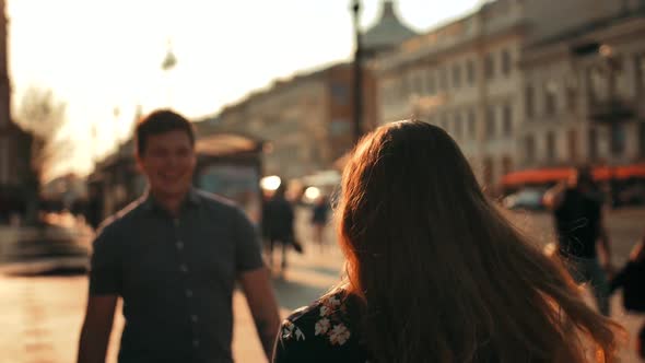 A Male Meeting a Female Walking Down the Street and Giving Her a Huging, Close Up. Turn Around.