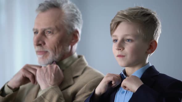 Senior and Young Men Adjusting Bow Ties and Looking at Each Other, Male Party