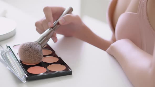 Closeup beauty young asian woman applying makeup with brush cheek on face.