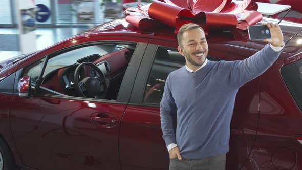 The Cute Man Doing Selfie on the Background of a Car