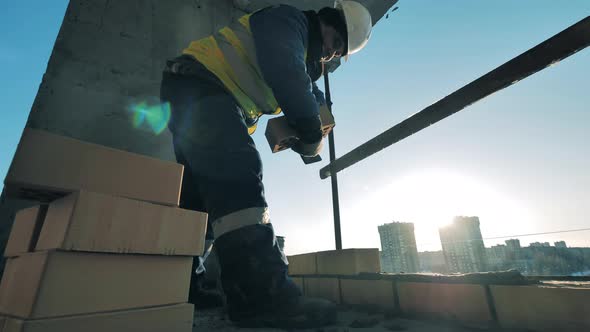 Construction Worker Is Laying Bricks and Cement alt
