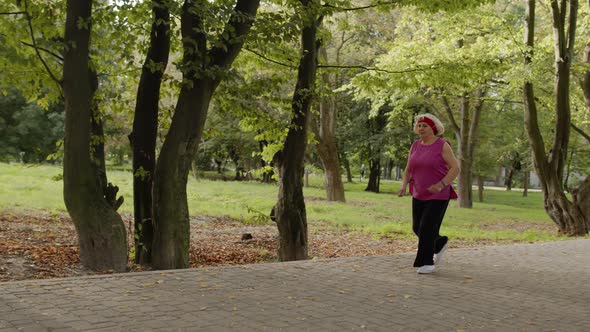 Senior Old Woman Running in Park and Using Smart Watch. Female Runner Working Out Cardio Outdoor