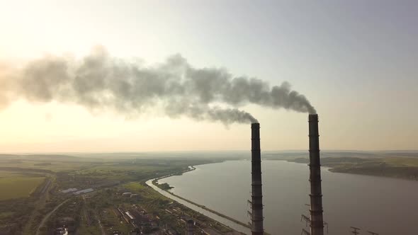 Aerial view of tall chimney pipes with gray dirty smoke from coal power plant. Production 