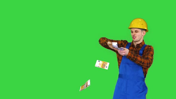 Costruction Worker in Yellow Hard Hat Throwing Money in the Air on a Green Screen, Chroma Key
