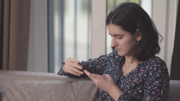 Portrait of a Girl Teenager with a Phone in Her Hands Uses a Mobile Application