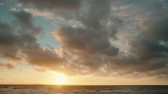 A golden idyllic sunset as the sun sets into the sea