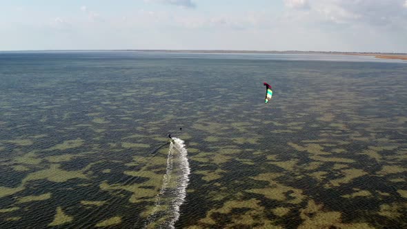 People go kitesurfing on the sea. The wind carries the athlete along the sea waves.