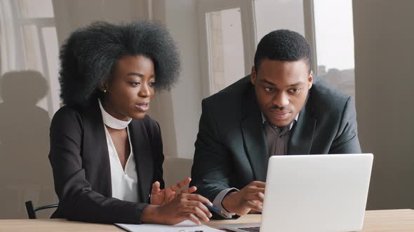 Male African Manager Mentor Teach Help Focused Female Intern Trainee New Employee Explain Computer