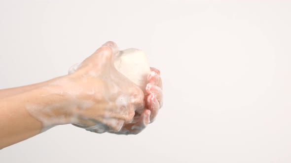 Caucasian woman washing her hands with bubbly soap bar isolated on white background