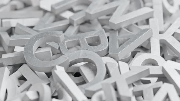 Full Frame Closeup Looped Slowly Rotating Background of Silver Metal Letters with Selective Focus