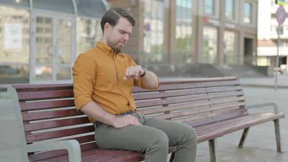 Waiting Young Man Leaving Bench after Checking Time