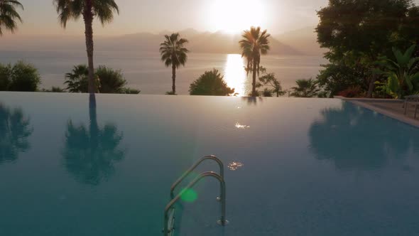 Swimming Pool on Resort with Sea and Mountains View, Scene at Sunset