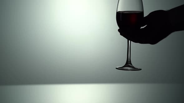 Man's Hand Takes Red Wine Forms Beautiful Wave