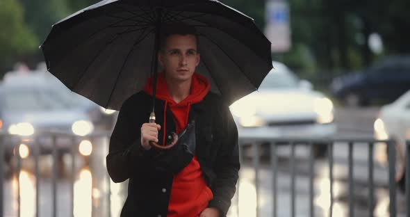 Man Walking in City Under Umbrella