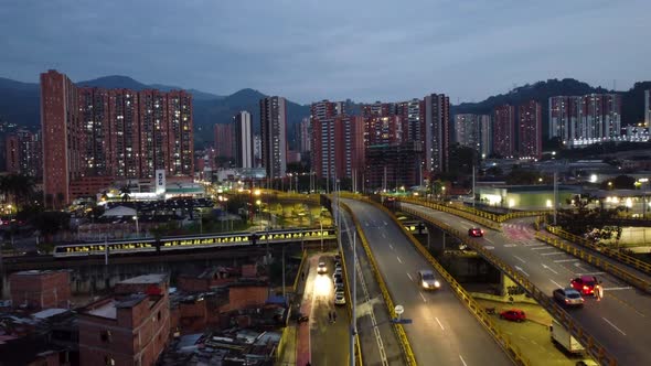 Medellin city at night, light traffic and lights. View of the city subway passing a station. Excelle