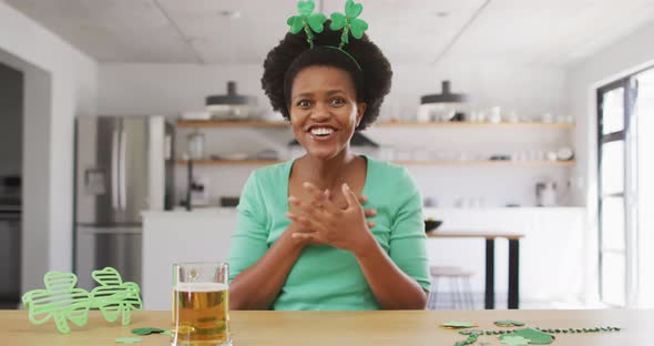 Happy african american woman sitting at table,making video call