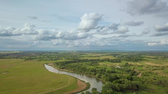 Flight Over Green Meadow and River in Spring