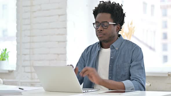 Young African Man Having Headache on Laptop