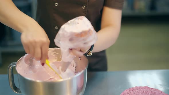 Confectioner in Uniform Puts Pink Cake Cream in Pastry Bag