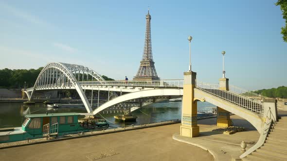A man running across a bridge with the Eiffel Tower.