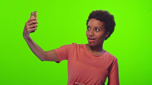 Lovely Glad Black Woman Smiles Broadly Takes Selfie Portrait on Smartphone