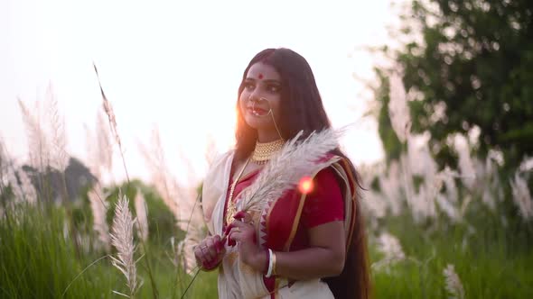 A beautiful and thoughtful Indian woman is happy and thinking about something in a calm way in a fie