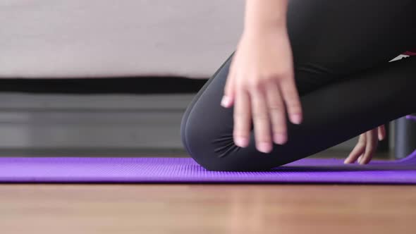 B roll shot of woman roll out yoga mat for preparation. Close up view on hand when open mat