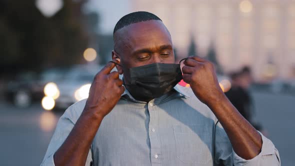 Adult Mature African American Man Takes Off Black Protective Medical Mask From Face Exhales Feels