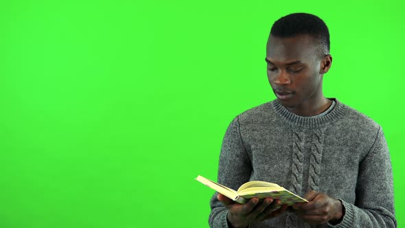 A Young Black Man Reads a Book - Green Screen Studio