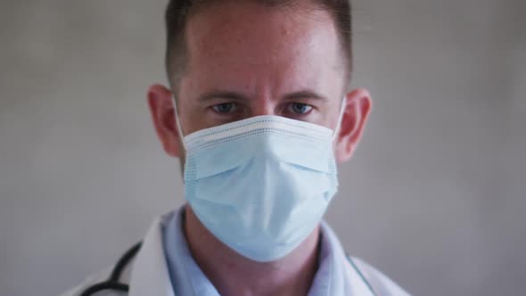 Portrait of caucasian male doctor wearing face mask